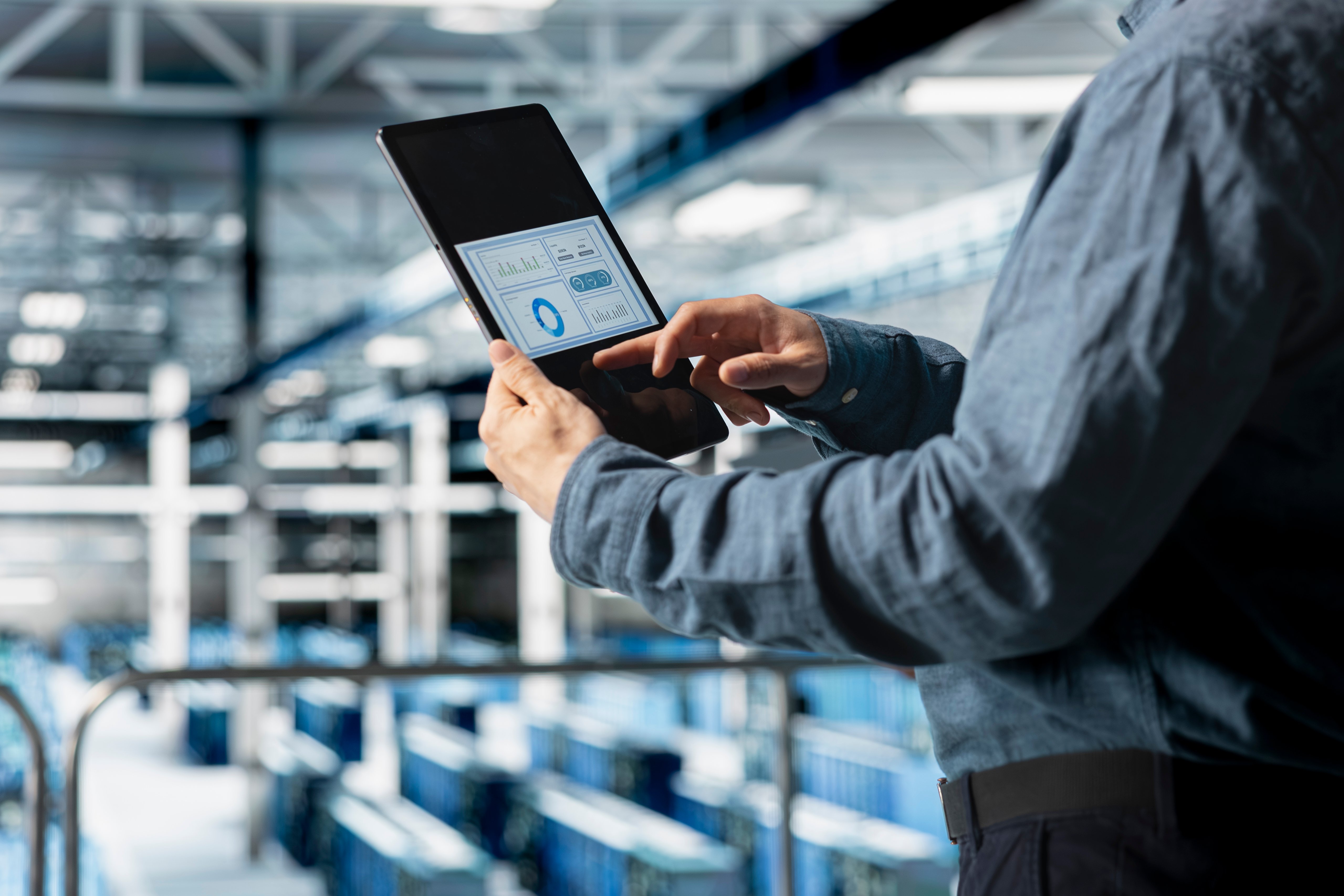 close-up-server-room-employee-analyzing-equipment-metrics-device-screen