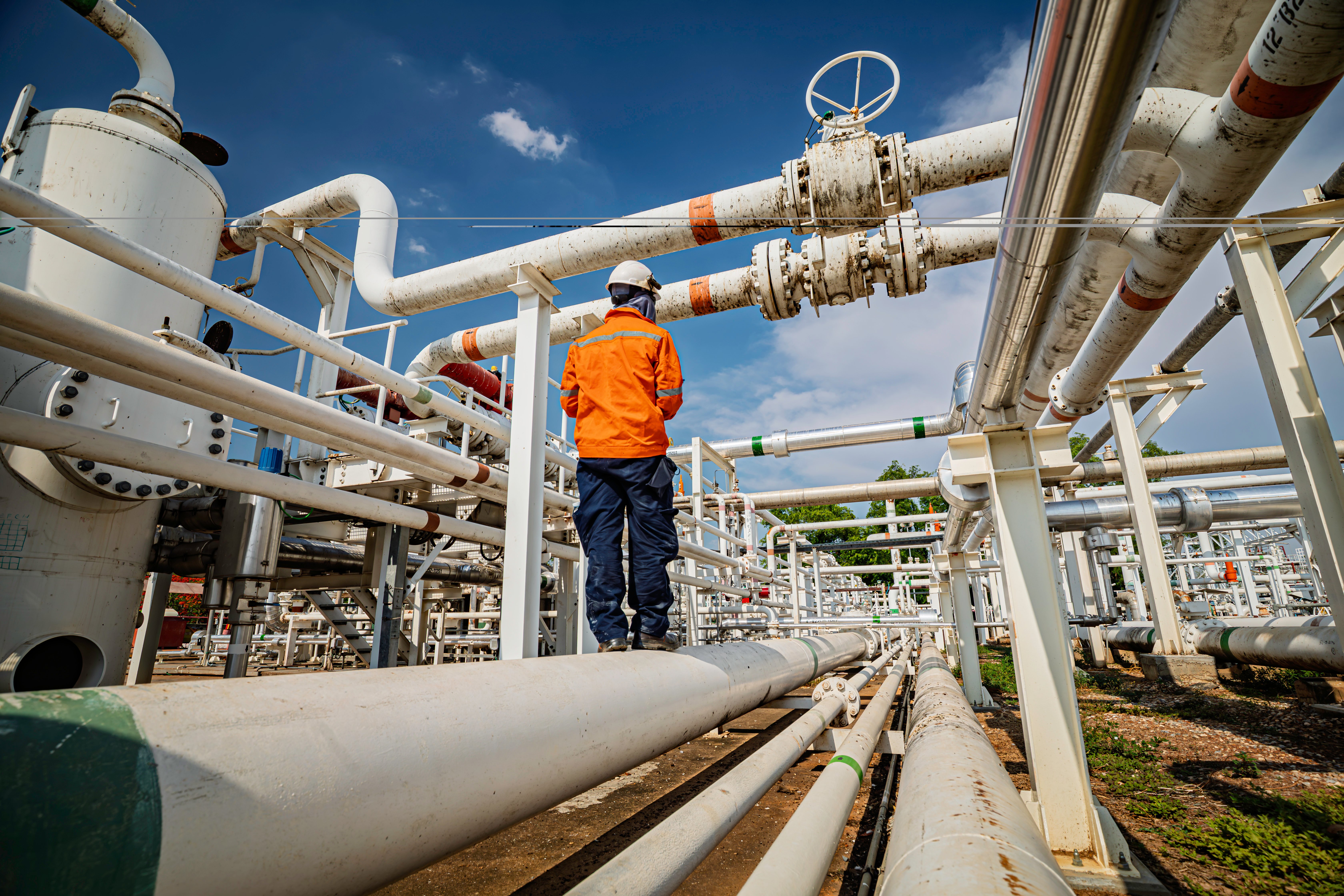 male-worker-inspection-steel-long-pipes-pipe-elbow-station-oil-factory-refinery-valve-visual-check-record-pipeline