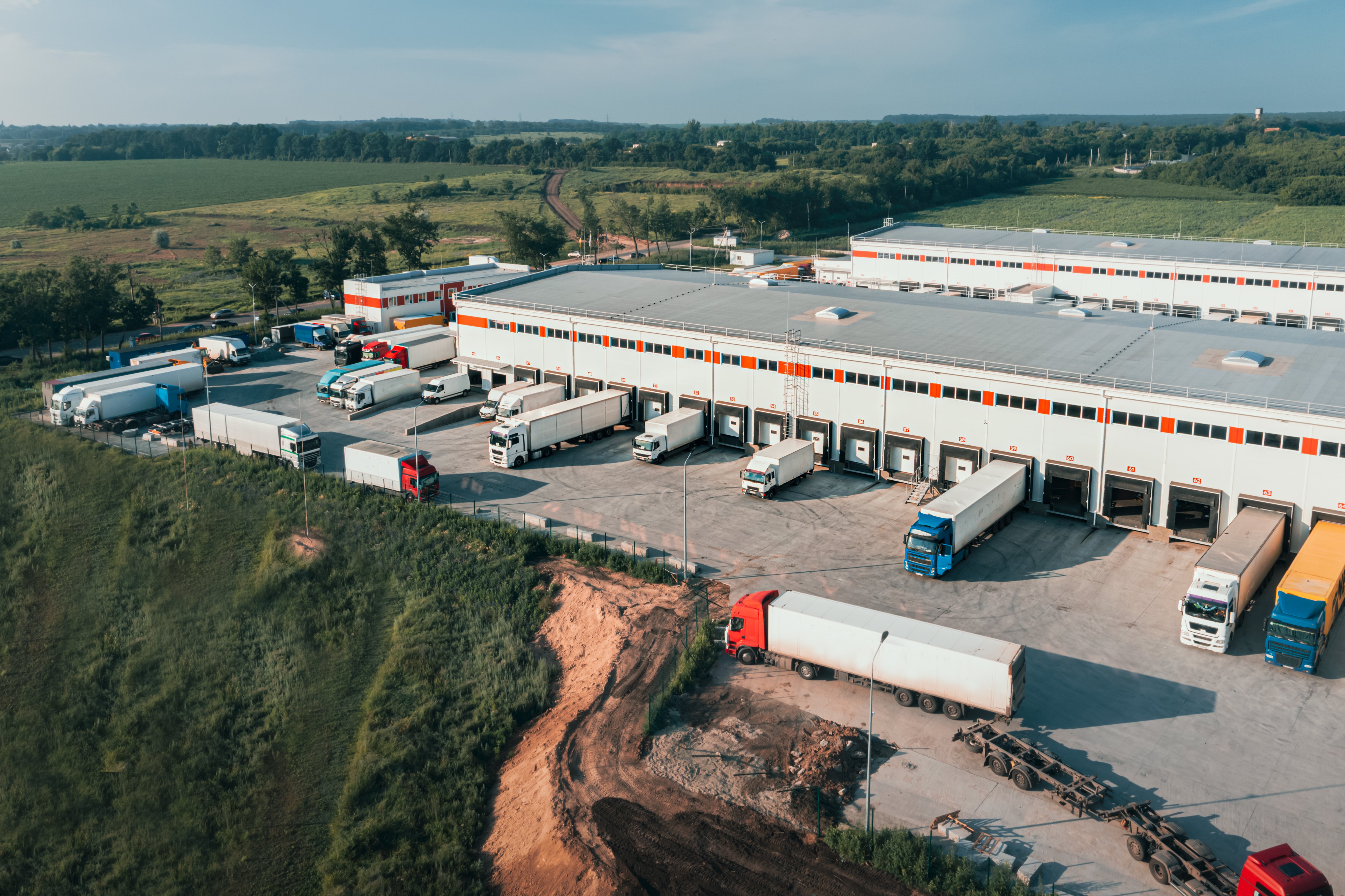 trucks-with-trailers-are-loaded-unloaded-cargo-terminal-morning-aerial-shot-contai